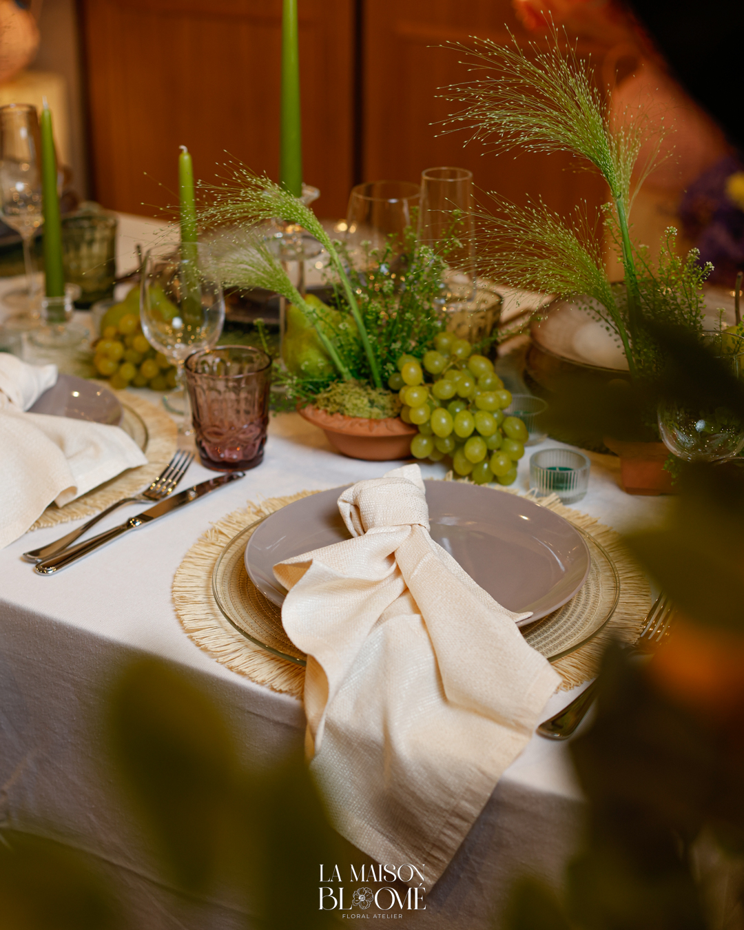 Tavola con candele verdi, pere e uva